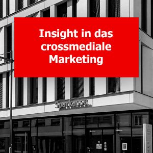 Graustufenfoto der Sparkassen-Filalie in Kempten. Darauf befindet sich ein rotes Rechteck mit einem weißen Text "Insight in das crossmedial Marketing".